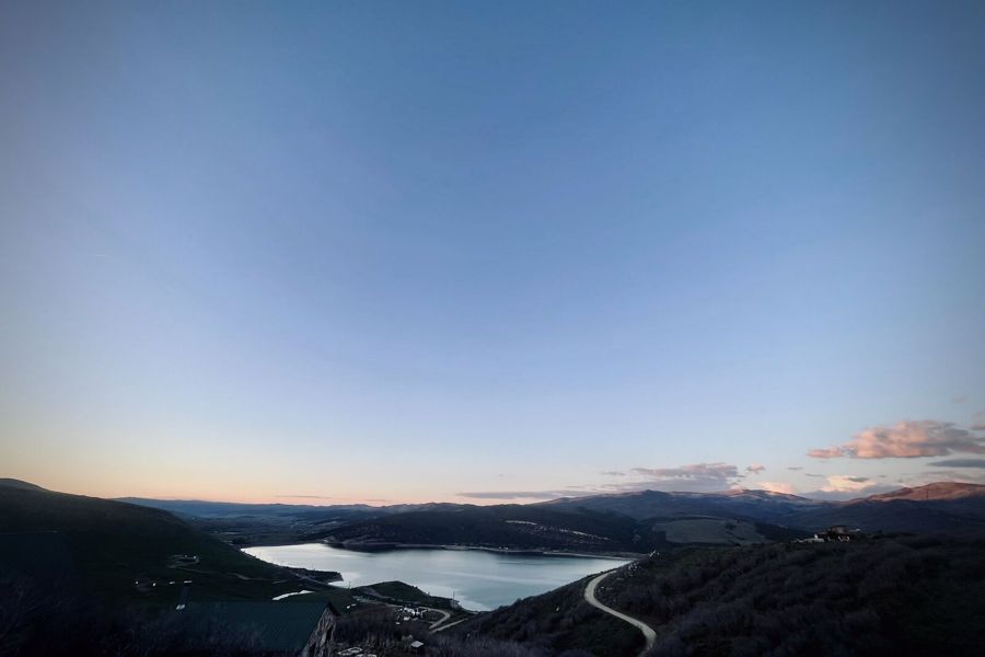 Twilight landscape over a mountain reservoir near Coalville, Utah, with a single road descending into the valley.